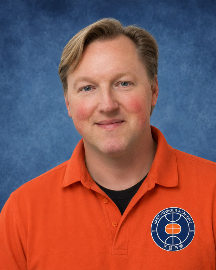 Kris Tyte, wearing an East Voyager Academy polo, in front of a blue backdrop